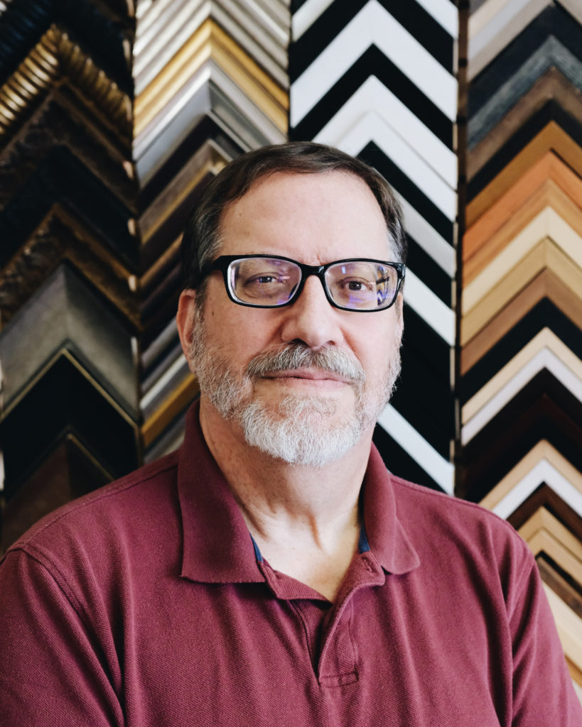 Ed with glasses, one of the York PA framing experts at Framers' Workshop, working on custom picture framing